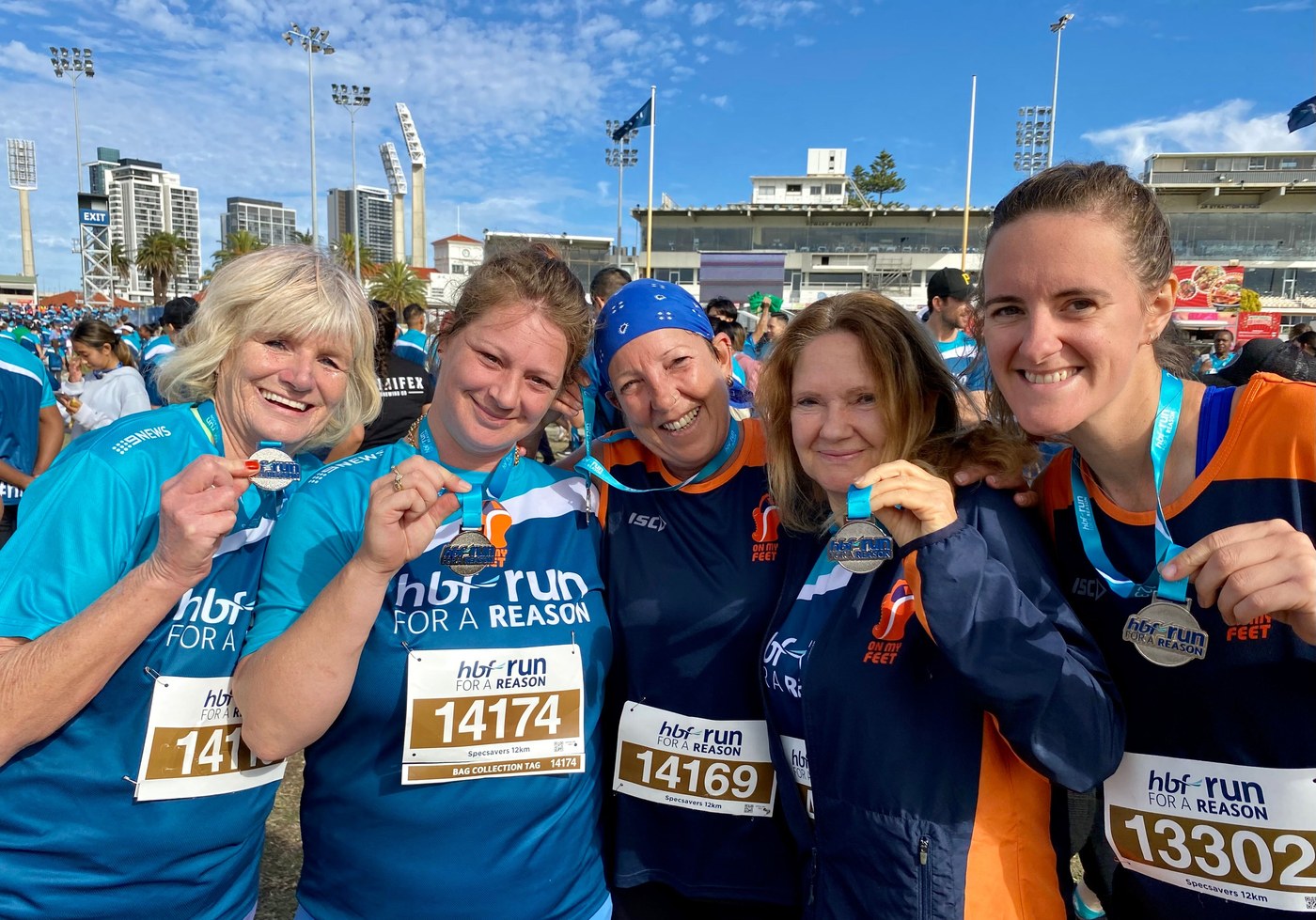 On My Feet runners celebrating with medals at the HBF Run for a Reason